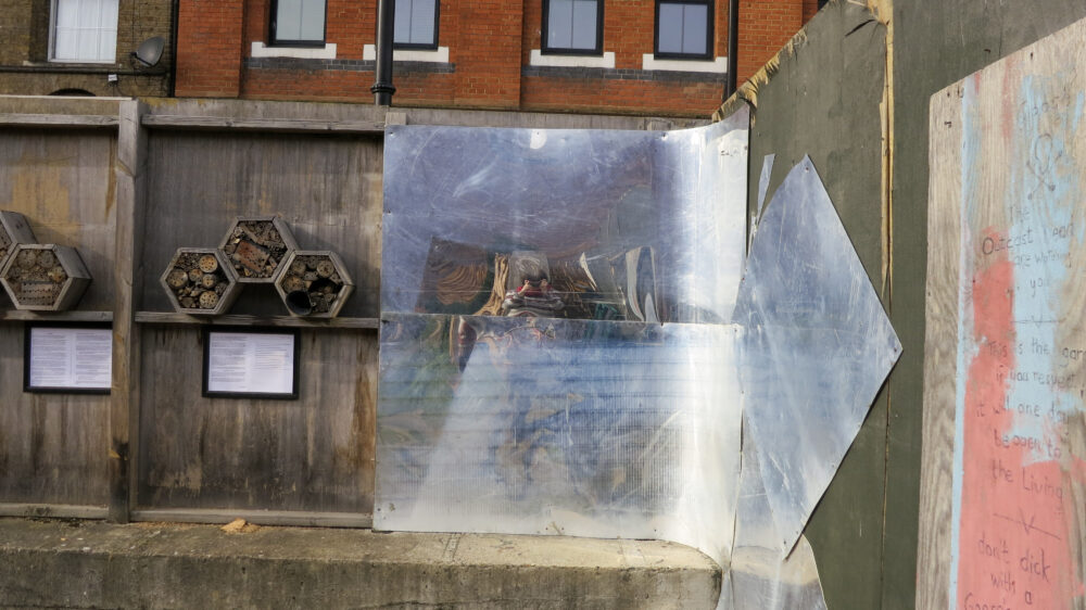 reflection of a photographer in a bent piece of metal